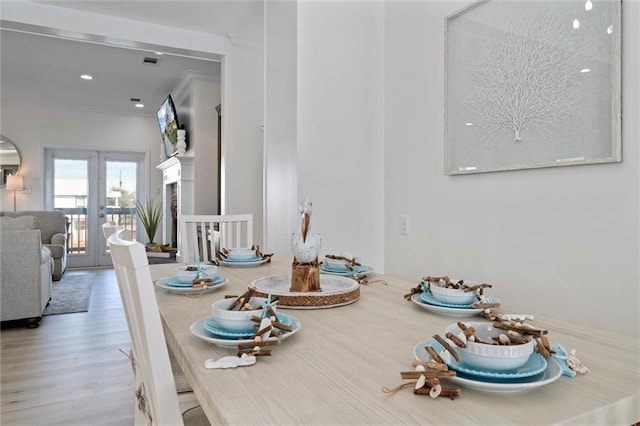 dining area featuring crown molding, french doors, and light hardwood / wood-style floors