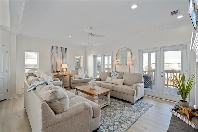 living room featuring ceiling fan, light wood-type flooring, a wealth of natural light, and french doors