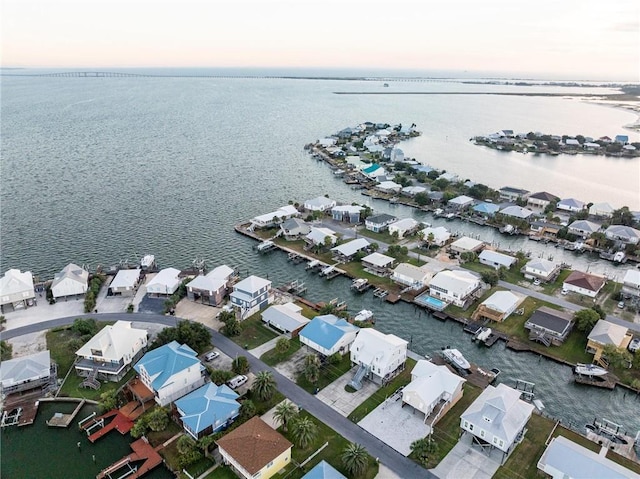 aerial view at dusk featuring a water view