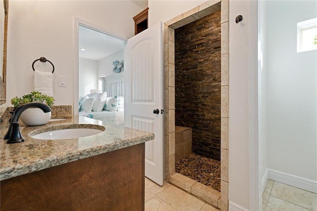 bathroom with tile patterned flooring, vanity, and walk in shower