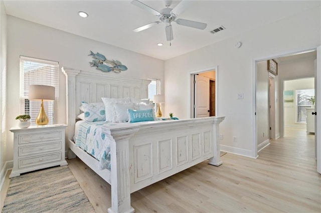 bedroom featuring multiple windows, ceiling fan, and light hardwood / wood-style flooring