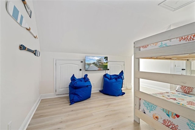 bedroom featuring vaulted ceiling and light wood-type flooring