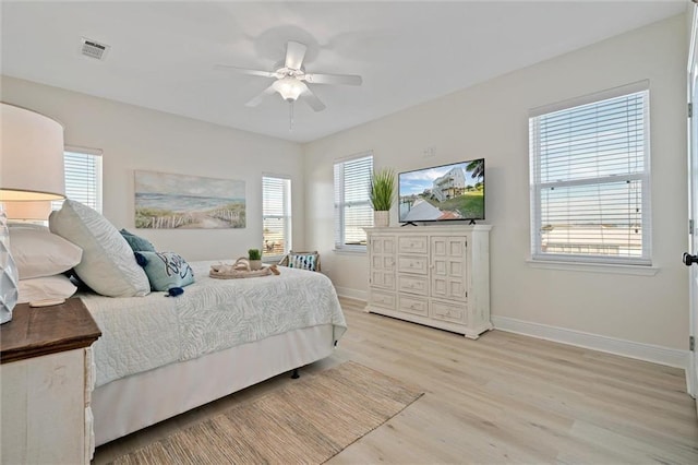 bedroom with ceiling fan, light wood-type flooring, and multiple windows