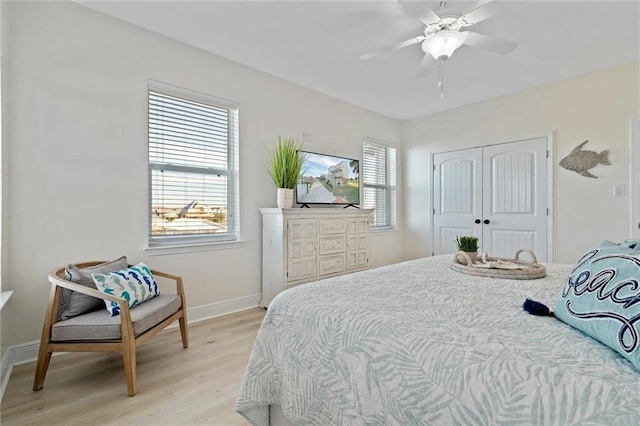 bedroom with light wood-type flooring, a closet, and ceiling fan