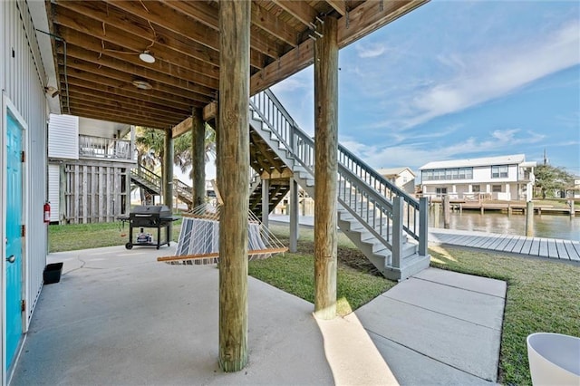 view of patio with grilling area and a water view