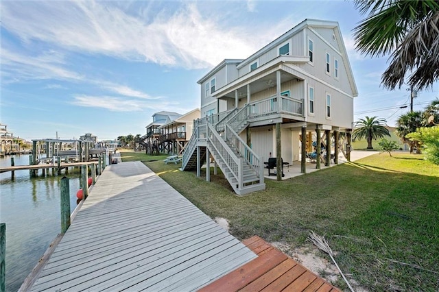 dock area with a water view and a lawn