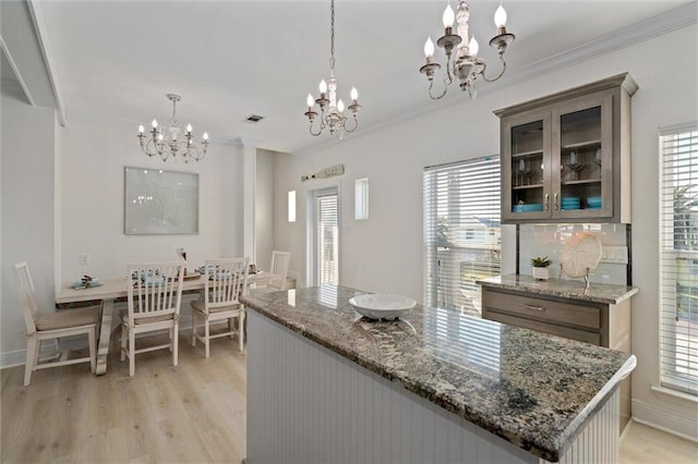 kitchen with light stone countertops, hanging light fixtures, and a notable chandelier