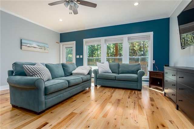 living room with crown molding, ceiling fan, a healthy amount of sunlight, and light wood-type flooring