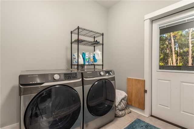 laundry room with washer and dryer and light tile patterned floors