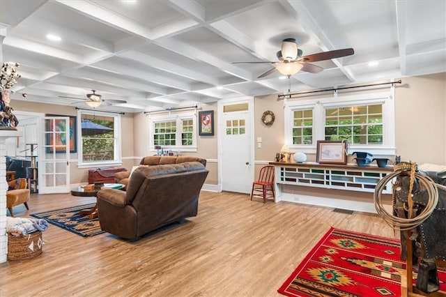 living area featuring wood finished floors, ceiling fan, coffered ceiling, and beamed ceiling