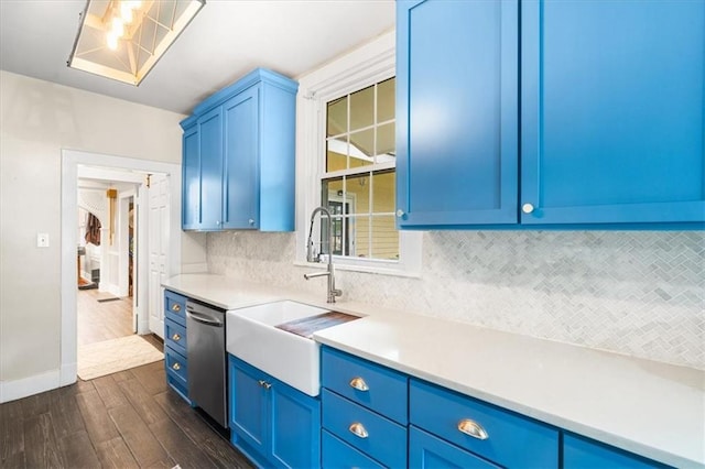 kitchen featuring dark wood-style floors, decorative backsplash, light countertops, dishwasher, and blue cabinets