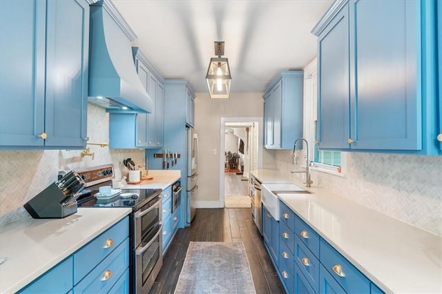 kitchen featuring appliances with stainless steel finishes, custom exhaust hood, blue cabinetry, and a sink