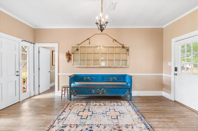 foyer entrance featuring ornamental molding, a notable chandelier, wood finished floors, and baseboards