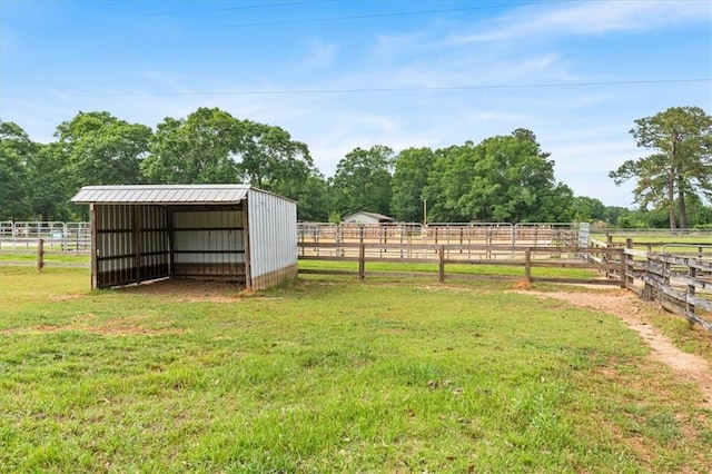 view of yard with a rural view, a detached carport, an exterior structure, and an outbuilding