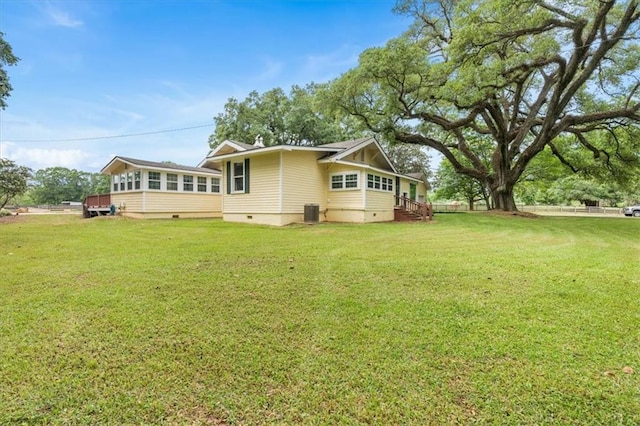 view of home's exterior with a lawn, central AC, and crawl space