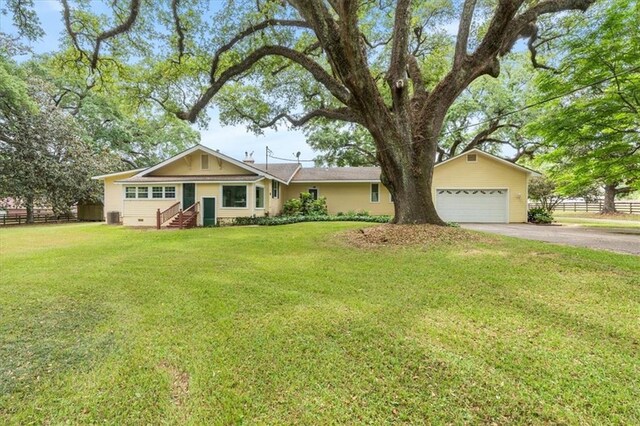 ranch-style house featuring fence, aphalt driveway, a front lawn, and a garage