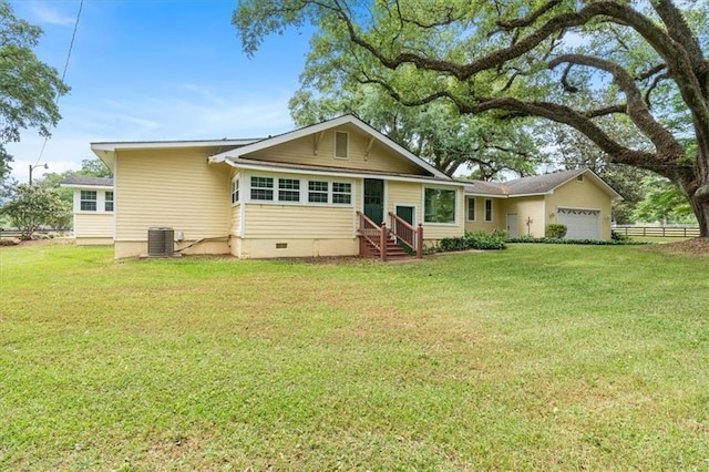 view of front of house with an attached garage, cooling unit, a front lawn, and entry steps