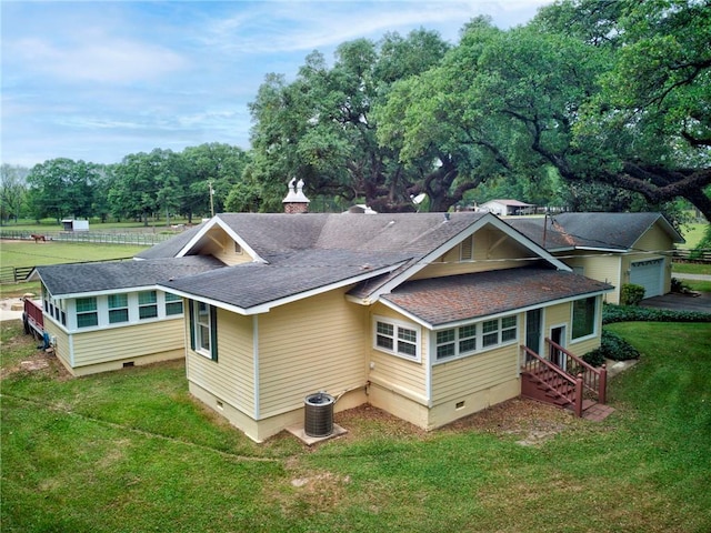 exterior space featuring a shingled roof, central air condition unit, entry steps, crawl space, and a lawn