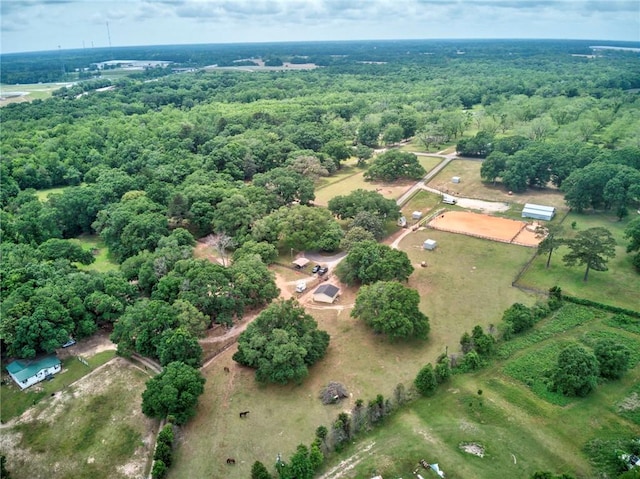 drone / aerial view with a wooded view and a rural view