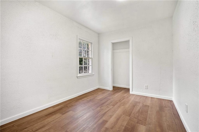 unfurnished bedroom with wood-type flooring and a closet