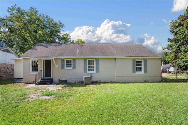 rear view of house featuring a yard and central air condition unit