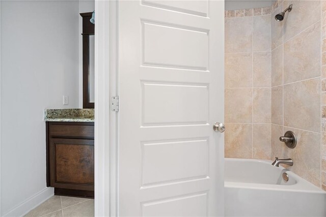 bathroom featuring tile patterned flooring, tiled shower / bath combo, and vanity