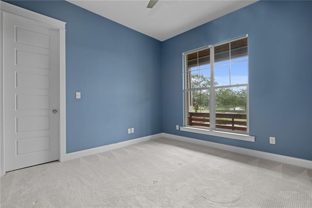 spare room featuring light carpet and ceiling fan