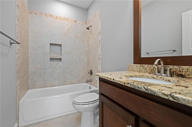 full bathroom featuring tile patterned floors, tiled shower / bath, vanity, and toilet