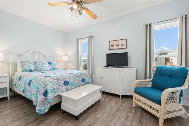 bedroom with hardwood / wood-style flooring, ceiling fan, and crown molding