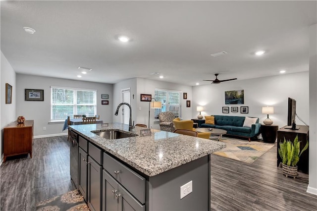 10804 Burlington Way N, Mobile, AL 36608 - kitchen featuring dark wood-style flooring, ceiling fan, gray cabinetry, a center island with sink, and light stone countertops