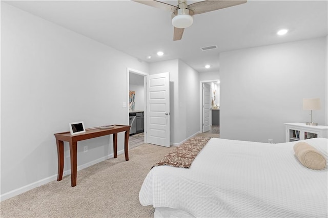 bedroom featuring light carpet, ensuite bath, and ceiling fan