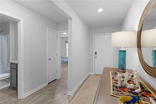 hallway with baseboards and light wood finished floors