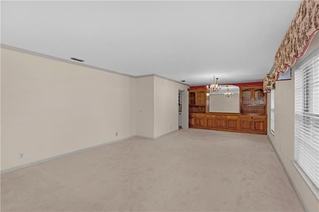720 Grand Bay-Wilmer Rd N, Mobile, AL 36608 - unfurnished living room featuring a chandelier, light colored carpet, ornamental molding, baseboards, and healthy amount of natural light