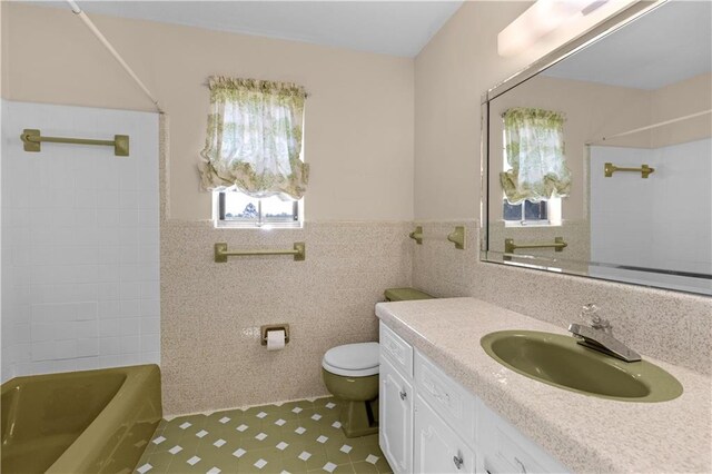 720 Grand Bay-Wilmer Rd N, Mobile, AL 36608 - bathroom featuring toilet, vanity, tile walls,  shower combination, and wainscoting