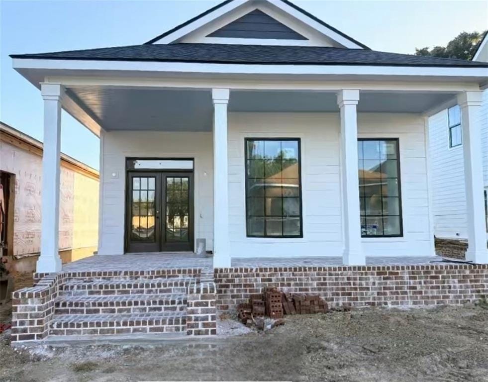 253 Dearborn St N, Mobile, AL 36603 - property entrance featuring a porch, roof with shingles, and french doors