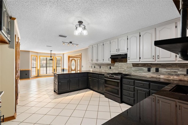 kitchen with double oven range, white cabinets, decorative backsplash, a textured ceiling, and light tile patterned flooring