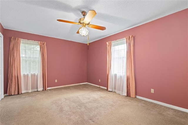 spare room with baseboards, a textured ceiling, ceiling fan, and carpet floors