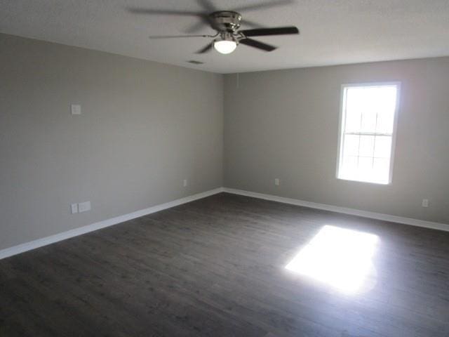 empty room featuring ceiling fan and dark wood-type flooring