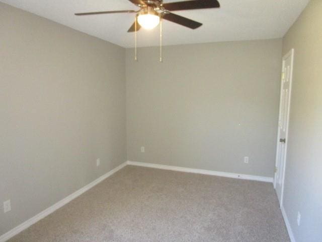 carpeted spare room with ceiling fan