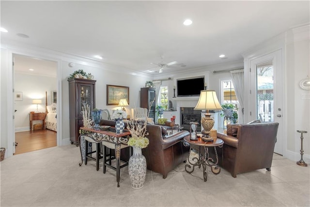 living room with a fireplace, recessed lighting, ornamental molding, and a ceiling fan