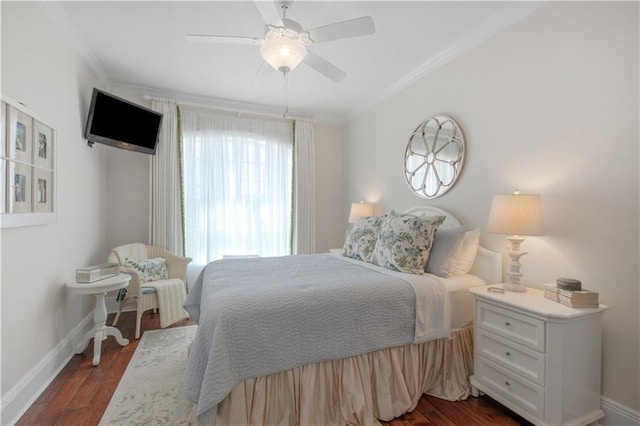bedroom featuring baseboards, ornamental molding, dark wood-type flooring, and a ceiling fan