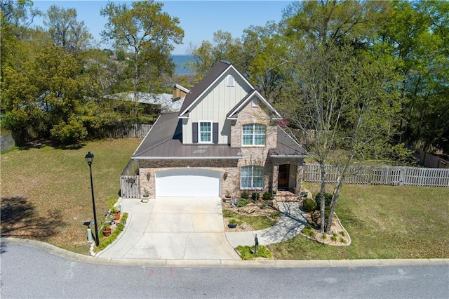 craftsman-style home featuring driveway, stone siding, fence, board and batten siding, and a garage
