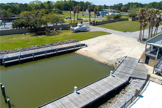 dock area with a lawn and a water view