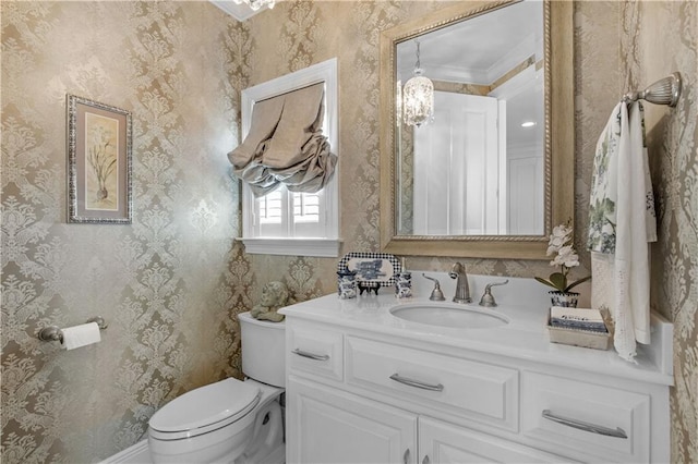 bathroom with wallpapered walls, vanity, toilet, and baseboards