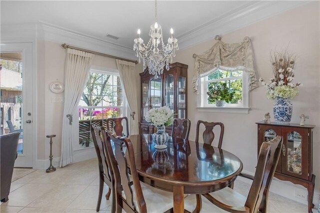 dining space with light tile patterned floors, ornamental molding, baseboards, visible vents, and a notable chandelier