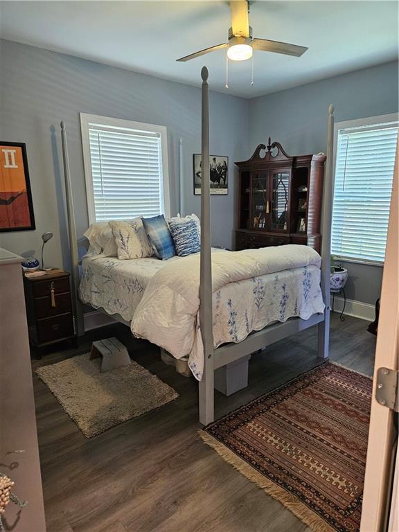 bedroom with baseboards, ceiling fan, and wood finished floors