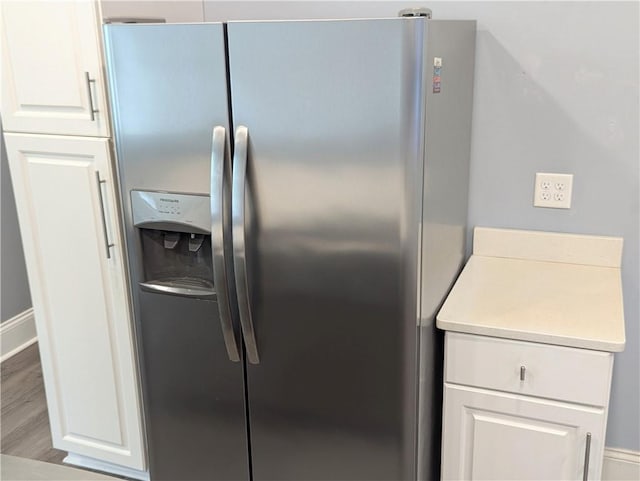 kitchen featuring light countertops, white cabinets, wood finished floors, and stainless steel refrigerator with ice dispenser