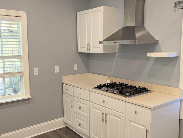 kitchen featuring a wealth of natural light, white cabinetry, wall chimney exhaust hood, and stainless steel gas stovetop