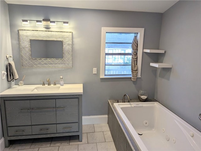 bathroom featuring vanity, baseboards, and a whirlpool tub