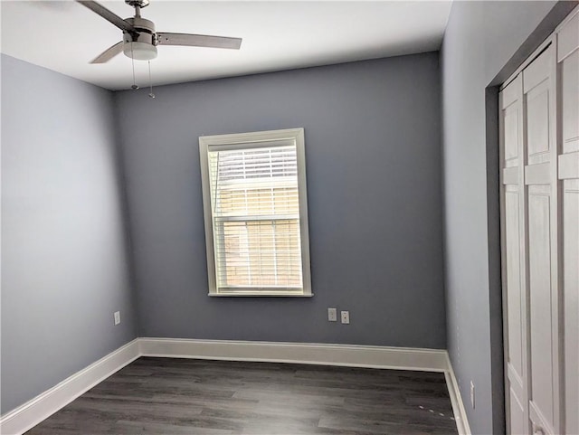 unfurnished bedroom featuring baseboards, a ceiling fan, and dark wood-style flooring